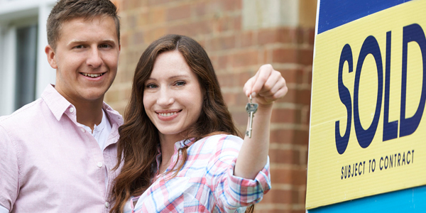 new home buyers collecting keys to their new home
